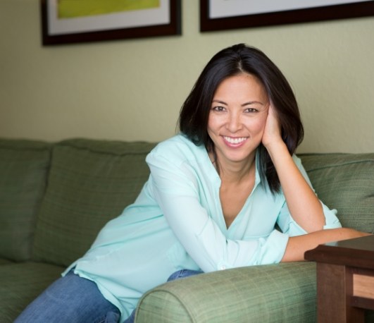 Smiling woman sitting on green couch