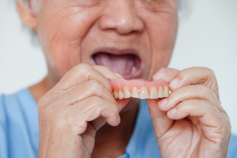 a person taking their dentures out