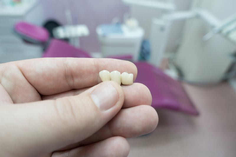 A dental bridge held in a person’s hand